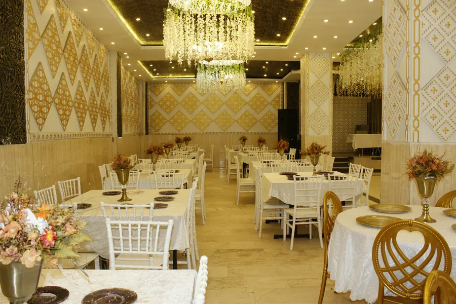 Salonun altın desenli duvarları ve masa sıraları